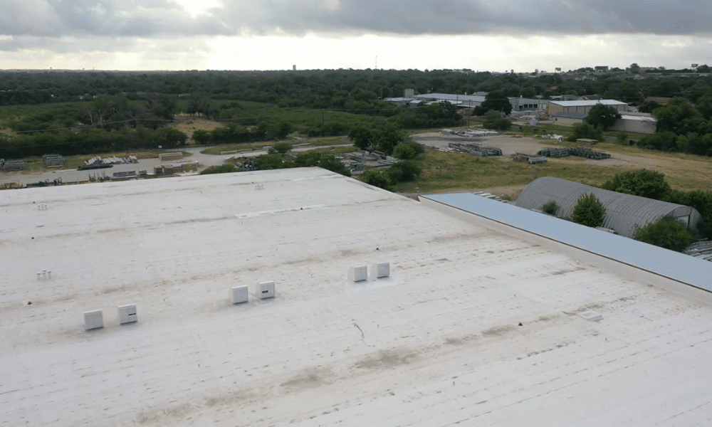 understanding wind uplift how strong winds compromise commercial roofing systems Flat commercial roof showing wind uplift damage and detached membrane—contact WaterTight Roofing for expert storm repair and prevention. Call 888-809-9976 now!